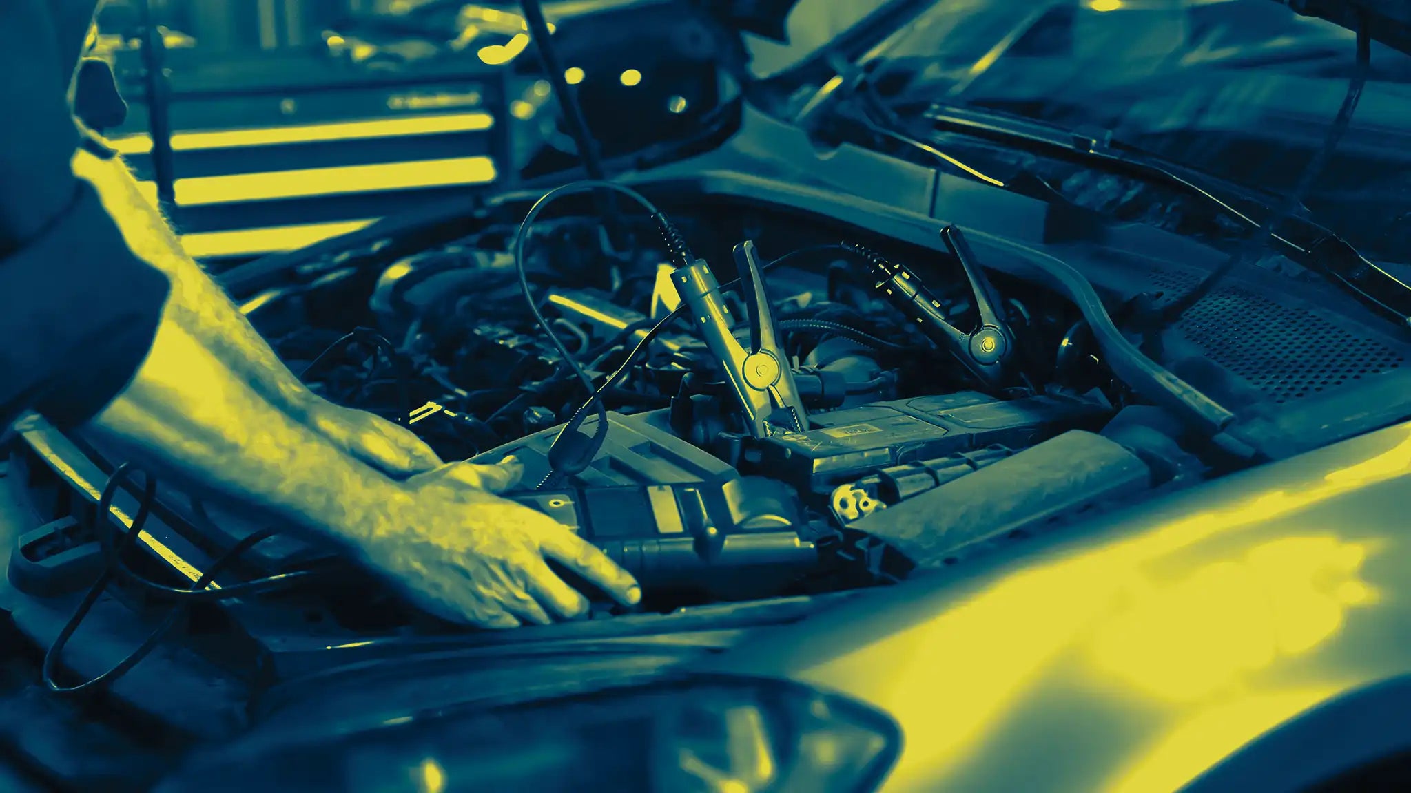 Auto electrician testing a vehicle battery system with a Durst battery charger holding stable voltage